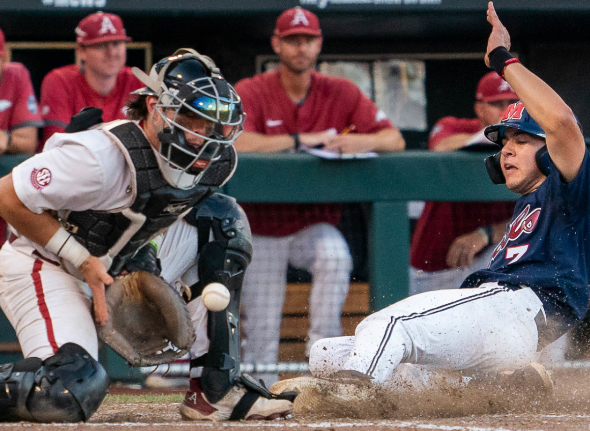 Razorbacks catcher Michael Turner takes a late throw at home in the 12-3 loss to Ole Miss on Monday evening at the College World Series in Omaha, Nebraska.